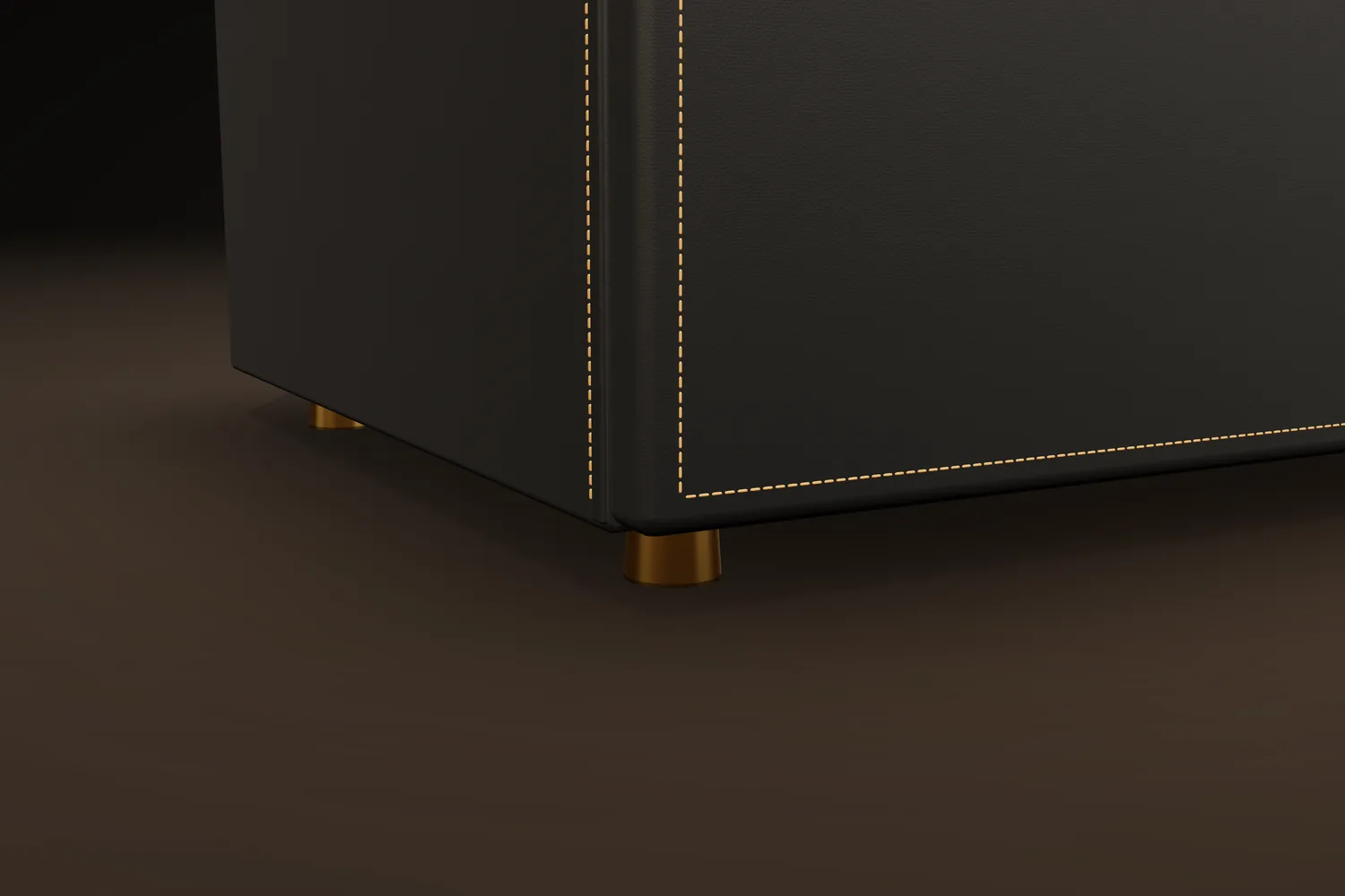 A brass foot beneath a black leather cabinet with tan contrast stitching